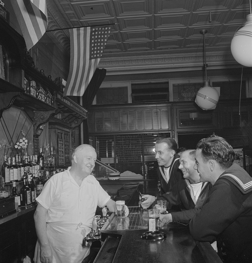 New York, New York. Irish-American bartender serving beer to British sailors in a Third Avenue bar in the "Forties"